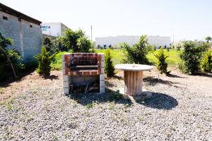 a bench and a table in a gravel yard at HOTEL & RV PARK ROSA EVELYN in San Quintín