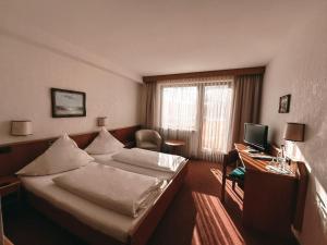 a hotel room with a bed and a desk with a computer at Hotel Bayerischer Hof in Bad Kissingen