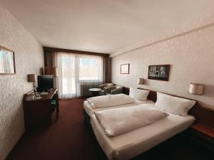 Habitación de hotel con 2 camas y TV en Hotel Bayerischer Hof en Bad Kissingen