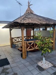 a wooden gazebo with a straw roof at Investigator Beach Breeze Apartments U1 in Kingscote