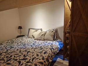 a bedroom with a bed with a blue and white comforter at Villa des Cigales in Trets
