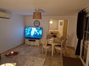 un soggiorno con tavolo e TV di Villa des Cigales a Trets