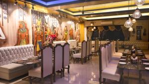un restaurante con mesas, sillas y pinturas en la pared en Tris Planet Kalyani by Easygorooms!!, en Kalyani