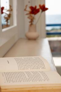 a book sitting on a table with a vase of flowers at Aura Paros in Logaras
