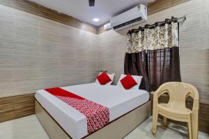 a bedroom with a bed and a chair at Hotel Vallabha Residency in Rājahmundry