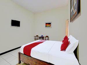 ジョグジャカルタにあるOYO 91920 Pondok'ku Innのベッドルーム1室(ベッド1台、赤と白の掛け布団付)