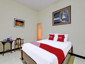 ジョグジャカルタにあるOYO 91920 Pondok'ku Innのベッドルーム1室(大型ベッド1台、赤い枕付)