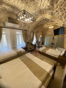 duża sypialnia z 2 łóżkami w kamiennym pokoju w obiekcie CARRA KONAĞI w mieście Mardin