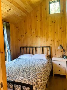 sypialnia z łóżkiem w drewnianej ścianie w obiekcie Vermont Scandinavian Chalet-Brévent w mieście Wolcott