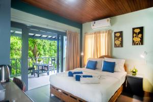 1 dormitorio con 1 cama grande y balcón en The Florist Resort, en Mae Nam