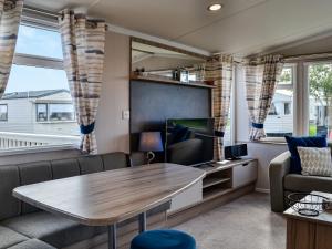 a living room with a table and a tv at Merse Place 154 - Uk45160 in Mainsriddle