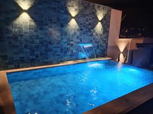 een zwembad met een waterval in een hotelkamer bij GZ GUEST HOUSE in Cuenca