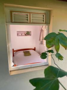 a small bedroom with a bed in a window at T2 - 50m du bourg de Sainte-Anne in Sainte-Anne