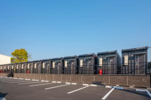 una fila de contenedores negros en un estacionamiento en HOTEL R9 The Yard Narita Kukou Nishi, en Narita