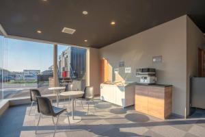 a kitchen with chairs and a table and a counter at HOTEL R9 The Yard Narita Kukou Nishi in Narita