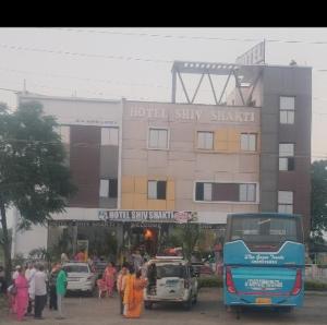 un autobús azul estacionado frente a un edificio en Hotel Shiv Shakti en Mohaniā