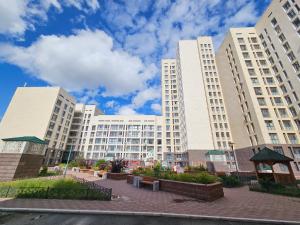 un grupo de altos edificios blancos en una ciudad en Ernaz Plus Apartments: Promenade Expo en Astaná