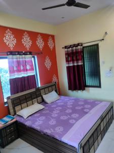 1 dormitorio con 1 cama grande con sábanas moradas en Hotel Shiv Shakti en Mohaniā