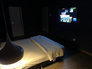a bedroom with a bed with a television and a chair at SACRAMENTO in Rodadero
