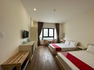 Habitación de hotel con 2 camas y mesa en Capital O 1208 Phong Van Villa, en Da Lat