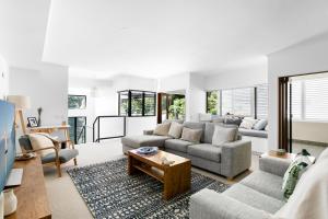 a living room with couches and a table at Papillon Coolum in Coolum Beach