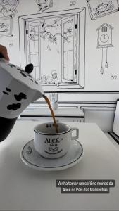 Pousada das Águas في لامباري: شخص يصب القهوة في كوب على طاولة