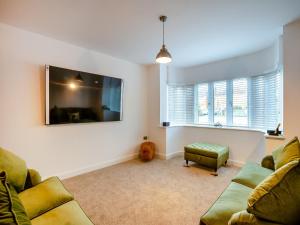 a living room with two couches and a flat screen tv at Doves Nest in Ashbourne