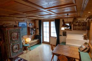 ein Wohnzimmer mit einem Tisch, einem Bett und einem Fenster in der Unterkunft Casa Lacedel 1, on ski slopes in Cortina d'Ampezzo