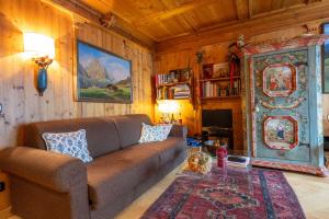 een woonkamer met een bank en een tv bij Casa Lacedel 1, on ski slopes in Cortina dʼAmpezzo