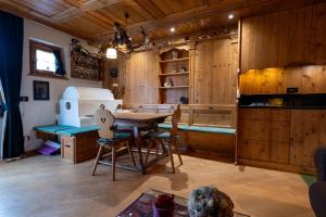 cocina con paredes de madera, mesa y sillas en Casa Lacedel 1, on ski slopes en Cortina dʼAmpezzo