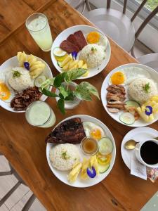 Anlio Resort في داويس: طاولة خشبية عليها صحون طعام
