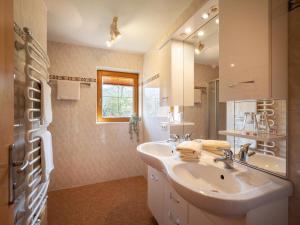 a white bathroom with a sink and a mirror at Apartment-Pension Schmiedererhof in Sankt Johann in Tirol