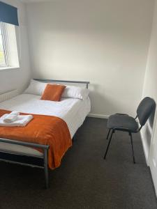 a bedroom with a bed and a chair in it at The Coral Guest House 3 Winchester in Winchester