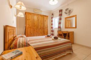 a bedroom with a bed and a wooden cabinet at Pool & Sea Merill Apartments Mellieha in Mellieħa +53 photos