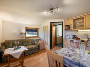 Apartment-Pension Schmiedererhof في سانت جوهان في تيرول: مطبخ وغرفة معيشة مع طاولة وأريكة