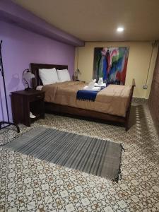 a bedroom with a bed and a painting on the wall at Zen Boutique House in Luang Prabang