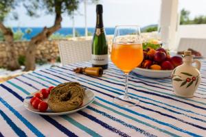una tavola con un piatto di cibo e un bicchiere di vino di Dimora Dei Turchesi a Gagliano del Capo