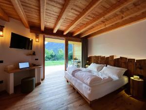 sypialnia z dużym łóżkiem i dużym oknem w obiekcie Agritur Maso Il Gioco w mieście Balbido-rango