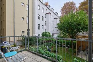 a balcony with chairs and a garden with buildings at Cityapartment für bis zu 8 Personen in Berlin
