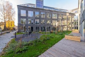 a large building with a garden in front of it at cohost I New Bastėja Life Apartments w-Garage Prkg & Self Check-in in Vilnius