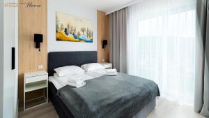 a bedroom with a bed with towels on it at Wonder Home - Domki Hillside tuż przy stoku narciarskim - na terenie kompleksu plac zabaw i zewnętrzna siłownia, sklep, parking in Karpacz