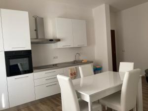 a kitchen with a white table and white cabinets at front streat 5 in Sassari