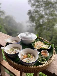 stół z miskami i talerzami jedzenia. w obiekcie Ban Oreo Homestay w mieście Ban Pha Hu