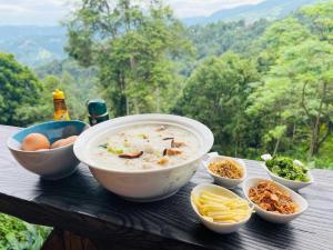 a bowl of soup and bowls of food on a table at Ban Oreo Homestay in Ban Pha Hu