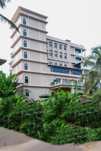 a large white building with trees in front of it at The Avenue Grand in Calangute