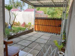 eine Außenterrasse mit einem orangenen Tor und Pflanzen in der Unterkunft BTN Mahkota Pemenang 13 Tamarin 3A in Pawenang