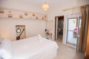 ein Schlafzimmer mit einem weißen Bett mit einer Uhr an der Wand in der Unterkunft Eirini's Traditional House in Lístaros