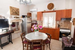 eine Küche mit einem Tisch und einer Blumenvase darauf in der Unterkunft Eirini's Traditional House in Lístaros