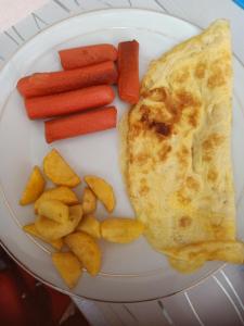 a plate of food with an egg and carrots and potatoes at Renata Cottages in Ohoililir