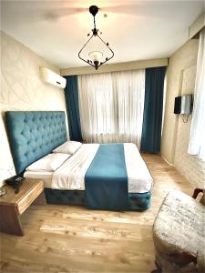a bedroom with a large bed with a blue head board at EVİM APART HOTEL in Termal